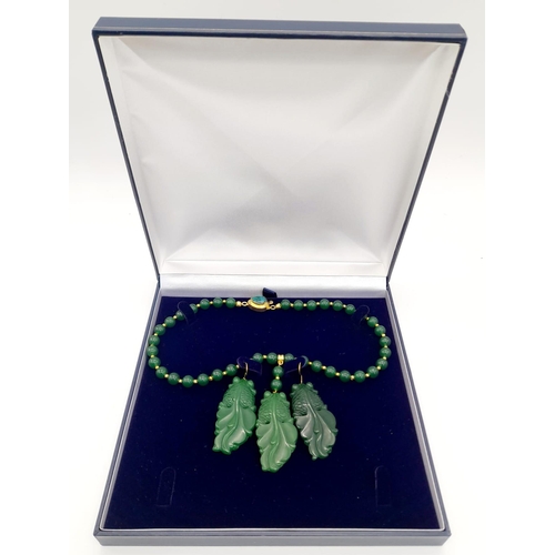 217 - A Chinese, green jade necklace and earrings set with large fancy tailed fish pendants, symbolising l... 