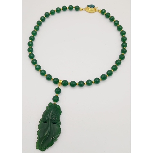 217 - A Chinese, green jade necklace and earrings set with large fancy tailed fish pendants, symbolising l... 