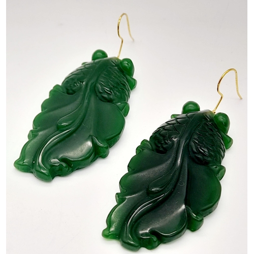 217 - A Chinese, green jade necklace and earrings set with large fancy tailed fish pendants, symbolising l... 