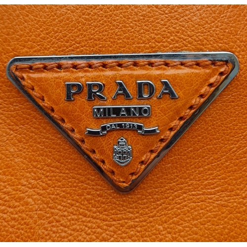 192 - A Prada Saffiano Double Zip Luxury Tote Bag. Burnt orange leather with silver tone hardware. Spaciou... 