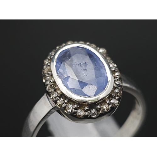 74 - A 1.84ct Oval Cut Blue Sapphire ring with Rose-Cut Diamond Surround - 0.16ct. Set in 925 silver. Siz... 