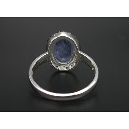 74 - A 1.84ct Oval Cut Blue Sapphire ring with Rose-Cut Diamond Surround - 0.16ct. Set in 925 silver. Siz... 