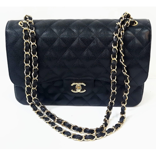 31 - A Classic Chanel Jumbo Flap Bag. Black quilted caviar leather. Gold tone CC logo clasp. Entwined adj... 