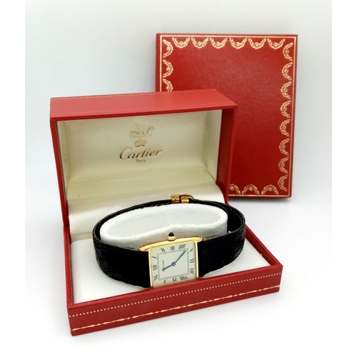 127 - A Vintage Cartier 18k Gold Unisex Tank Watch. Black leather strap. 18K gold case - 23mm width. White... 