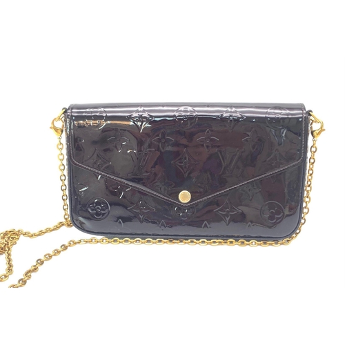 185 - A Louis Vuitton Burgundy Patent Leather Bag. Monogram exterior with gilded handle. Textile interior ... 