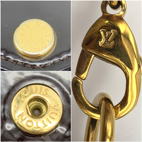 185 - A Louis Vuitton Burgundy Patent Leather Bag. Monogram exterior with gilded handle. Textile interior ... 