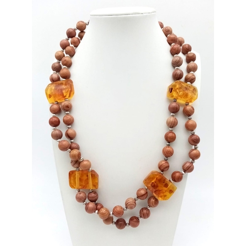 175 - A rare combination of fossil wood beads and amber, a two strand necklace in a presentation box. Leng... 