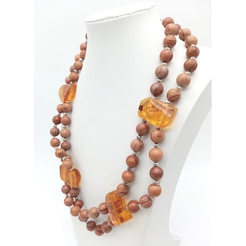 175 - A rare combination of fossil wood beads and amber, a two strand necklace in a presentation box. Leng... 