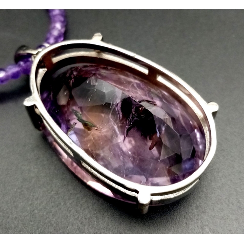 330 - A 71ct Amethyst Large Oval Gemstone Pendant with 0.15ct Diamond Accents on its Attachment Loop. Come... 