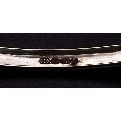 198 - A 9K White Gold and Diamond Wave Bangle. 6cmm inner diameter. Clip open clasp. 10 diamond wave. 5.69... 