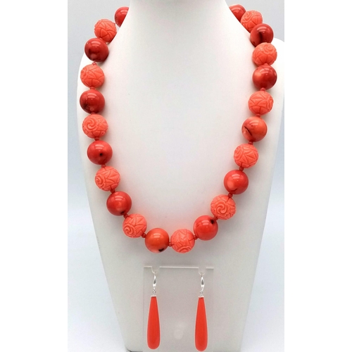 318 - A Carved Red Coral Bead Necklace and Drop Earrings. Beads - 15mm. Necklace - 48cm. Earrings 3.5cm dr... 