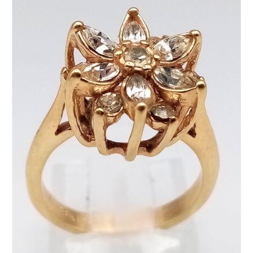 178 - A VERY PRETTY STONE SET 18K GOLD RING IN FLORAL FORM.   3.1gms   size J