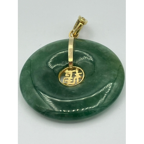 249 - JADE and GOLD PENDANT in circular form having GOLD CHINESE SYMBOL for Wealth  to centre. 2.75 cm dia... 