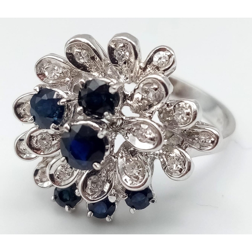 347 - An 18K White Gold Diamond and Sapphire Floral Burst Ring. Size O 1/2. 6.75g total weight.