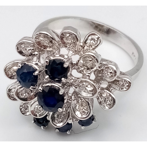 347 - An 18K White Gold Diamond and Sapphire Floral Burst Ring. Size O 1/2. 6.75g total weight.