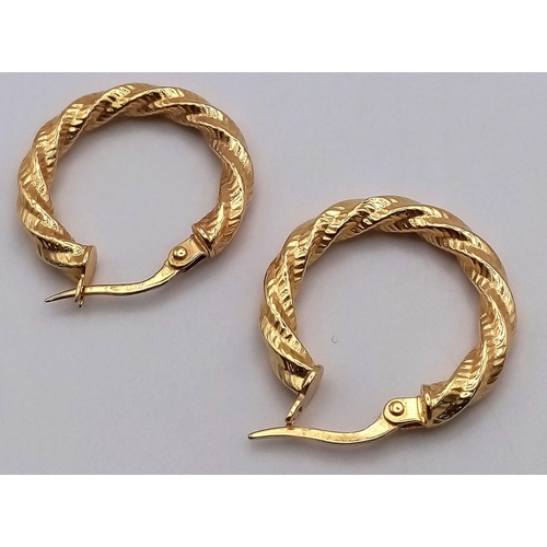 214 - A PAIR OF 9K GOLD BARKED HOOP EARRINGS . 1.1gms