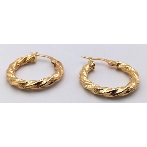 214 - A PAIR OF 9K GOLD BARKED HOOP EARRINGS . 1.1gms