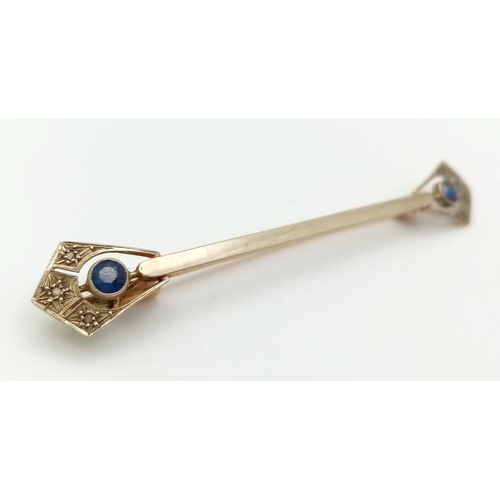 393 - An Antique 18K Gold and Sapphire Bar Brooch. Anglicanesque sapphire ends. 6cm. 2.7g total weight