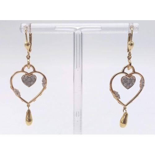 310 - A PAIR OF 14K GOLD AND DIAMOND HEART SHAPED EARRINGS .  5.3gms