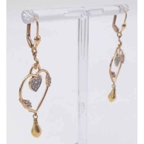 310 - A PAIR OF 14K GOLD AND DIAMOND HEART SHAPED EARRINGS .  5.3gms