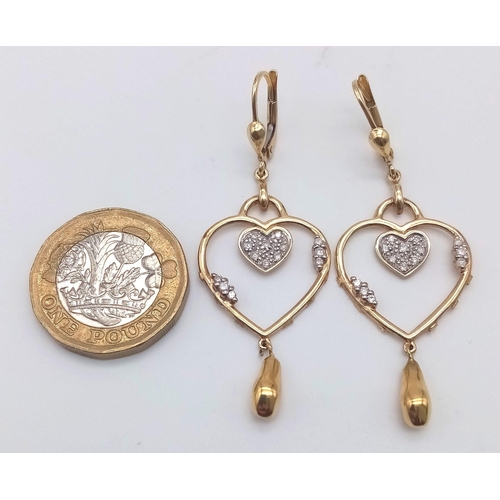 310 - A PAIR OF 14K GOLD AND DIAMOND HEART SHAPED EARRINGS .  5.3gms