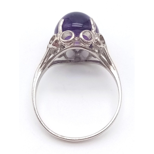 358 - AN AMETHYST CABOCHON SET IN 9K WHITE GOLD .  3.1gms   size N