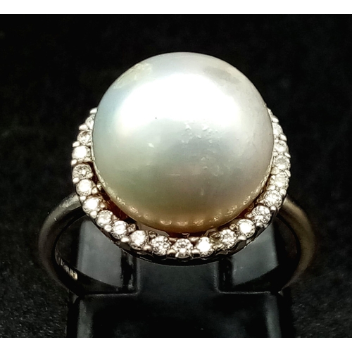 155 - A SOUTH SEA PEARL  RING SURROUNDED BY A HALO OF QUALITY DIAMONDS AND SET IN 18K WHITE GOLD .3.7gms  ... 