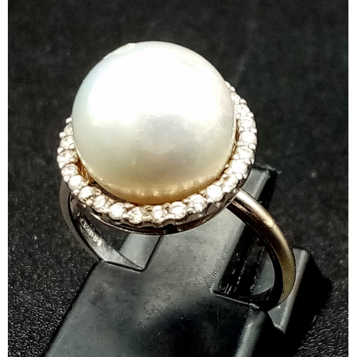 155 - A SOUTH SEA PEARL  RING SURROUNDED BY A HALO OF QUALITY DIAMONDS AND SET IN 18K WHITE GOLD .3.7gms  ... 