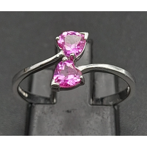 282 - A 9K White Gold Ring with Crossover Pink Topaz Gemstone Hearts. Size N 1/2. 1.65g total weight.