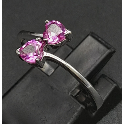 282 - A 9K White Gold Ring with Crossover Pink Topaz Gemstone Hearts. Size N 1/2. 1.65g total weight.