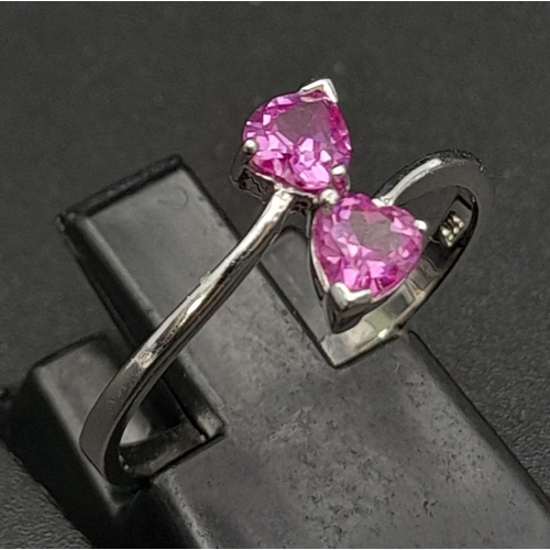 282 - A 9K White Gold Ring with Crossover Pink Topaz Gemstone Hearts. Size N 1/2. 1.65g total weight.