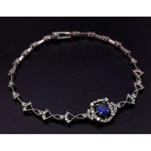 361 - An 18K White Gold, Diamond and Sapphire Bracelet. A central quality, clean sapphire surrounded by a ... 