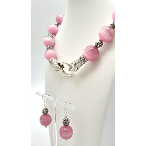 132 - A spectacular, large beaded (18 mm), pink cat’s eyes necklace with a Chinese silver snake clasp and ... 