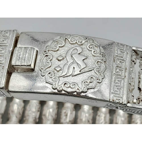 174 - A silver, Buddhist bracelet with beautifully engraved revolving prayer cylinders. In a quality, red ... 