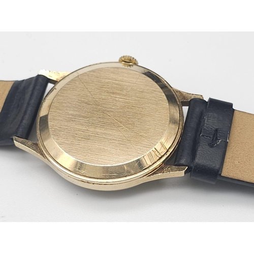 276 - A Vintage 9K Gold Garrard Gents Quartz Watch. Black leather strap. 9K Gold case - 34mm. Cream dial w... 