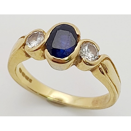 218 - An 18K Yellow Gold Sapphire and Diamond Ring. Central oval sapphire with a round cut diamond either ... 