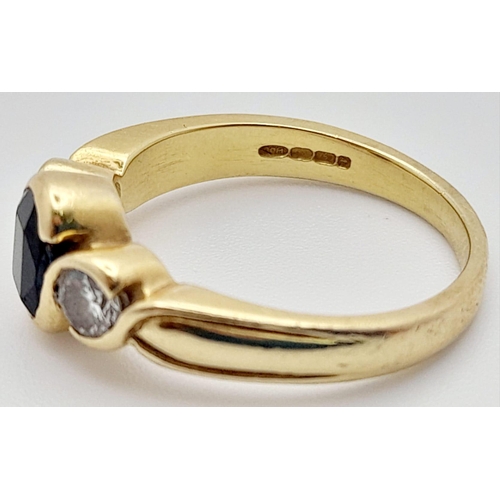 218 - An 18K Yellow Gold Sapphire and Diamond Ring. Central oval sapphire with a round cut diamond either ... 