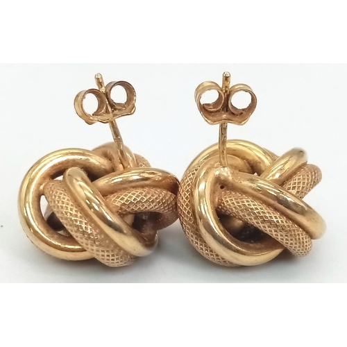 8 - A Pair of 9K Yellow Gold Knot Earrings. Smooth and geometric patterns entwined. 4.95g total weight.