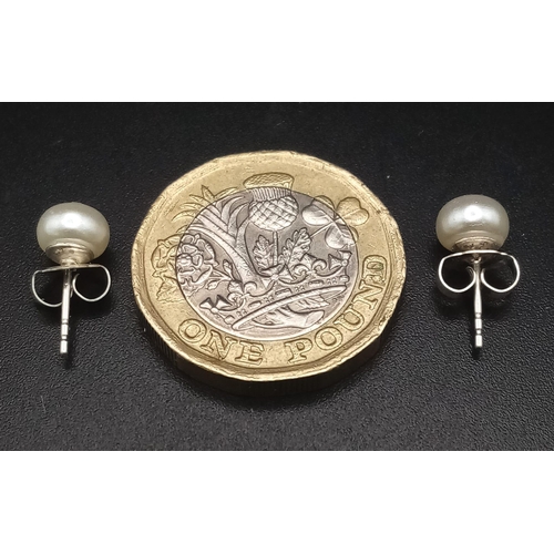 1748 - A PAIR OF SMALL PEARL STUD EARRINGS SET IN SILVER .  .55gms