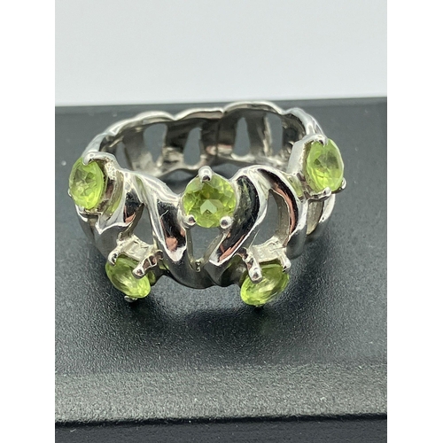 413 - Stunning SILVER and PERIDOT RING Consisting a Silver openwork band set with five round cut Peridot s... 