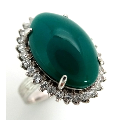 79 - A 18K WHITE GOLD GREEN JADE CENTRE STONE SURROUNDED BY DIAMONDS RING . 0.66CT  CABOCHON DIAMOND TOTA... 