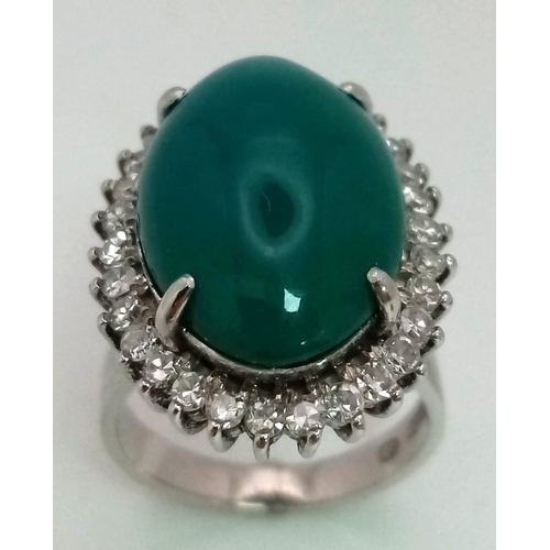 79 - A 18K WHITE GOLD GREEN JADE CENTRE STONE SURROUNDED BY DIAMONDS RING . 0.66CT  CABOCHON DIAMOND TOTA... 