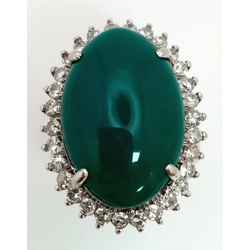 79 - A 18K WHITE GOLD GREEN JADE CENTRE STONE SURROUNDED BY DIAMONDS RING . 0.66CT  CABOCHON DIAMOND TOTA... 