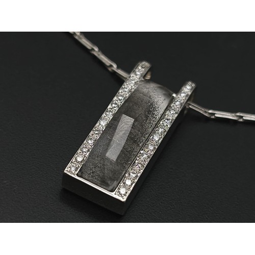 115 - An 18K White Gold Rutilated Quartz and Diamond Pendant on an 18K White Gold Link Necklace. A mesmeri... 