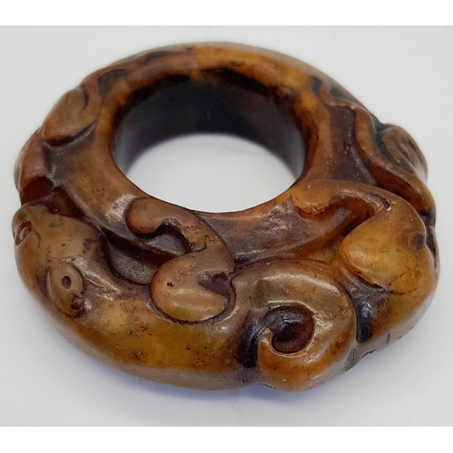 196 - An antique, hand carved jade ring with a panther and the mythical two headed snake. Dimensions: 42 x... 