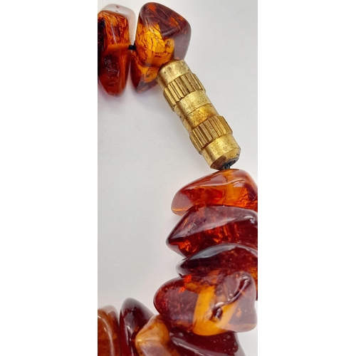 203 - A Baltic amber necklace with a large (55 x 37 x 15 mm) pear shaped cabochon pendant with organic deb... 