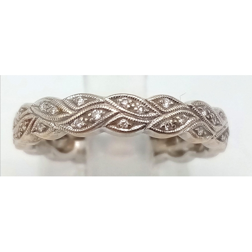 206 - A 18K WHITE GOLD DIAMOND DAISY CHAIN BAND RING. TOTAL WEIGHT 3.5G. SIZE L.