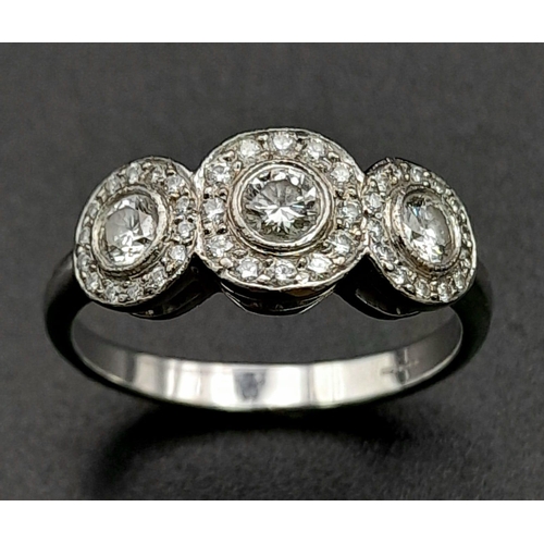 284 - A Tiffany and Co. 18K White Gold and Diamond Ring. A trilogy of round cut diamonds each with its own... 