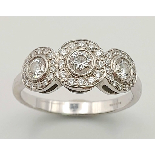 284 - A Tiffany and Co. 18K White Gold and Diamond Ring. A trilogy of round cut diamonds each with its own... 