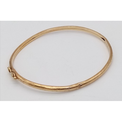 99 - A 9 K yellow gold bangle with an engraved design on surface. Weight: 3.5 g.